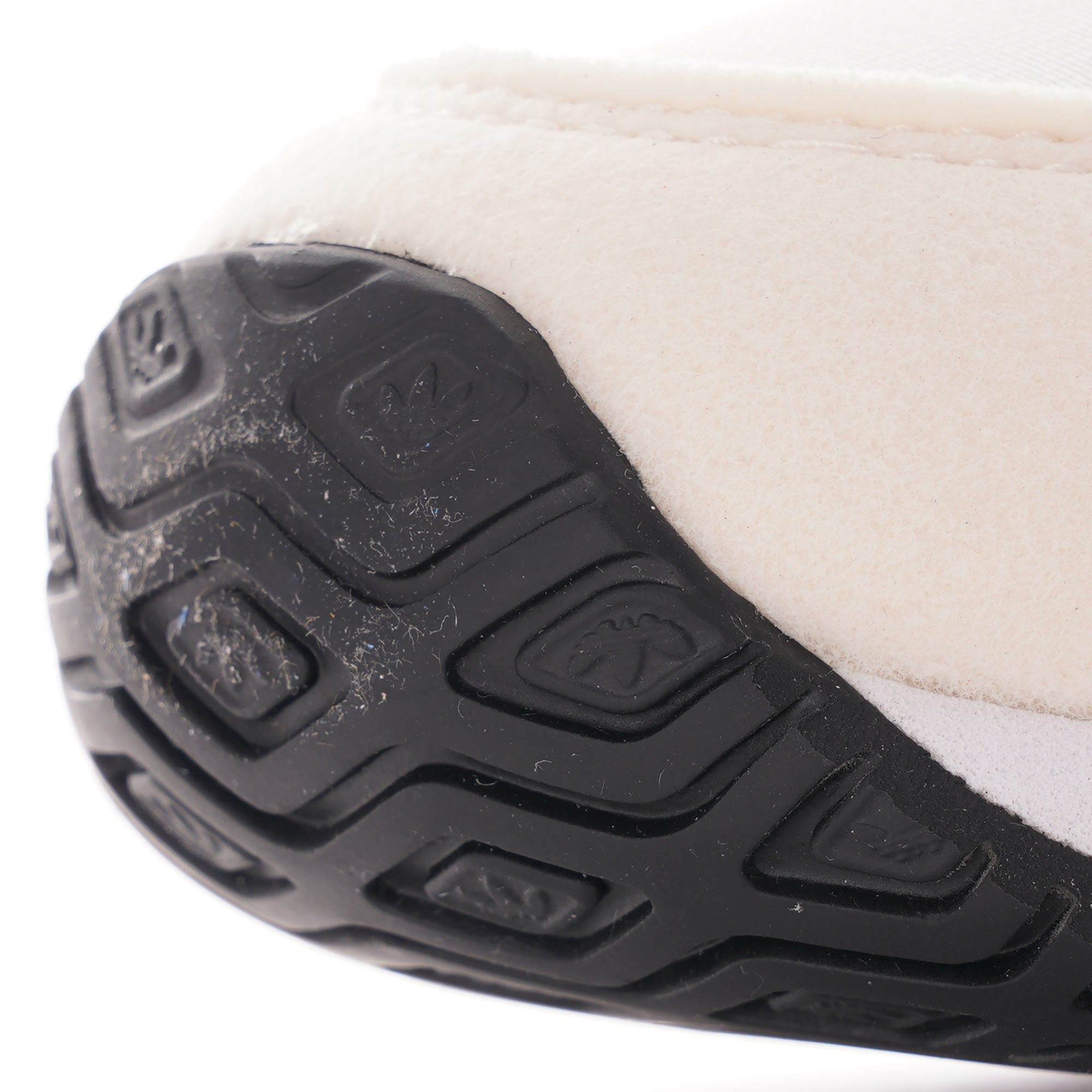 A close-up of the textured black sole of an Adidas USA 84 trainer.