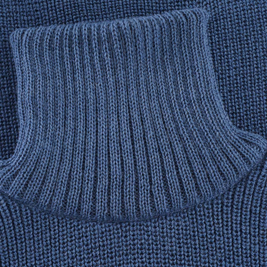 Close-up of the ribbed roll neck collar of the blue jumper.