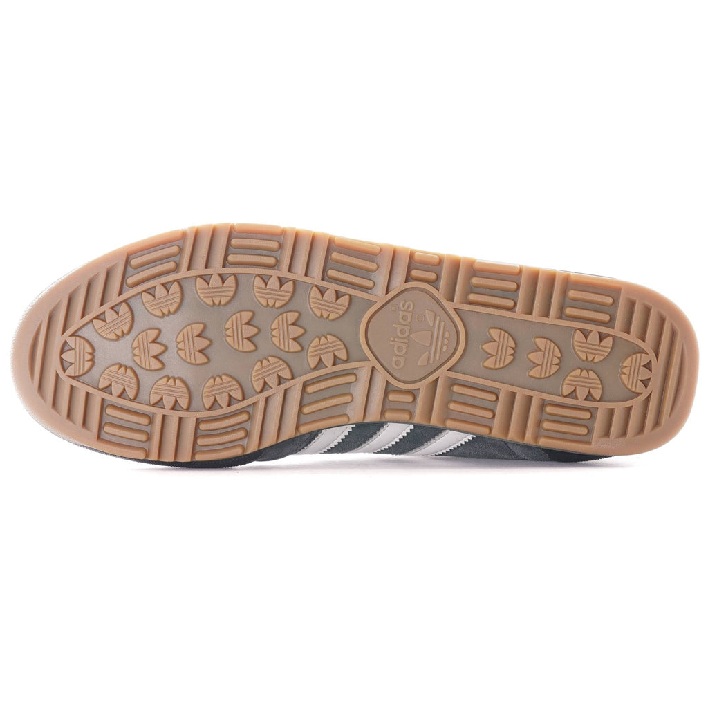 The textured brown sole of a grey Adidas Jeans trainer.