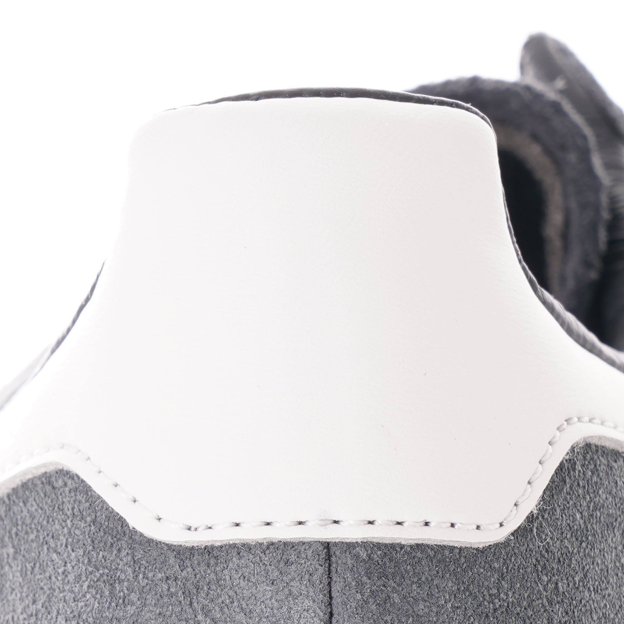 A close-up of the white heel tab on a grey Adidas trainer.