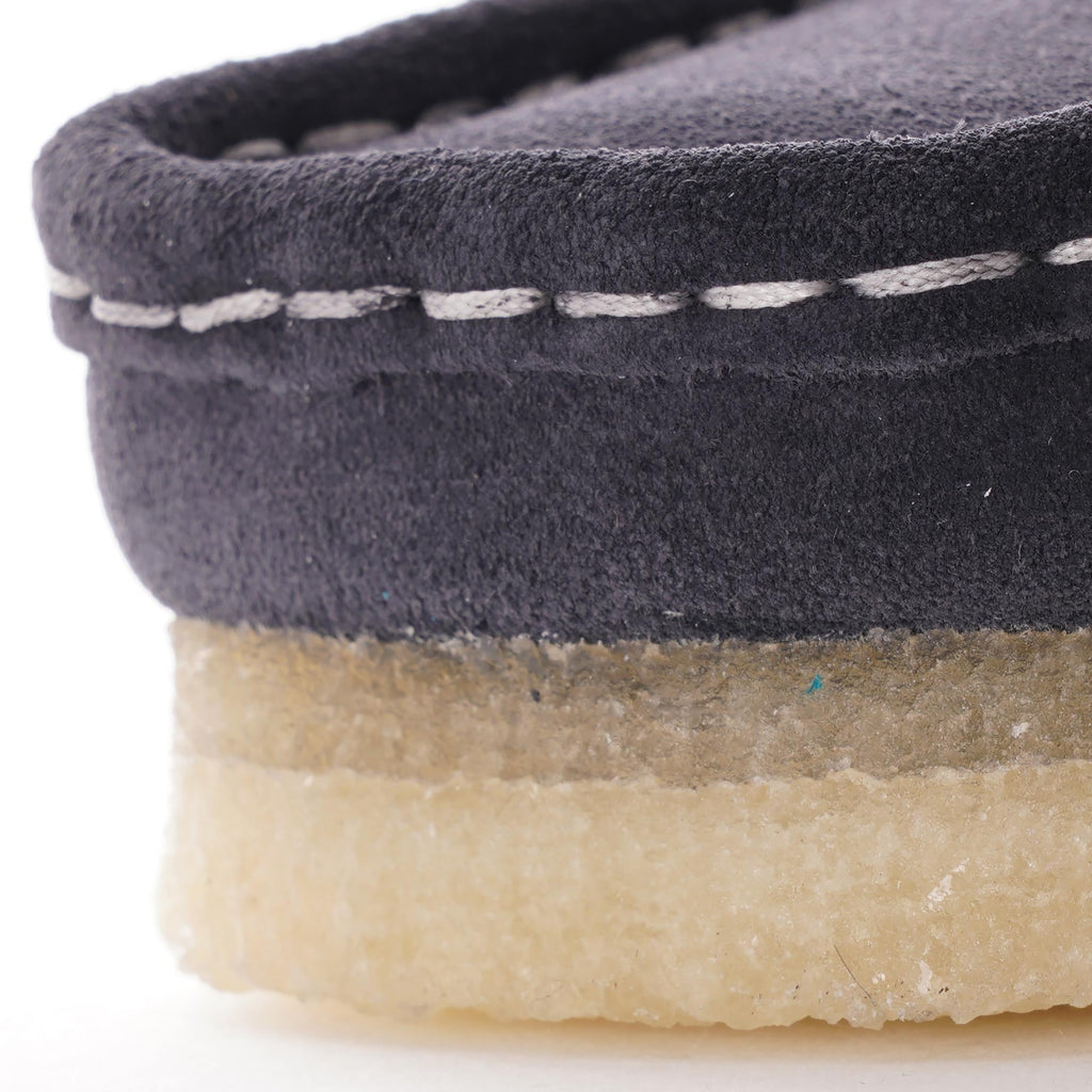 Close-up of the dark blue suede upper with white stitching and light brown crepe sole.
