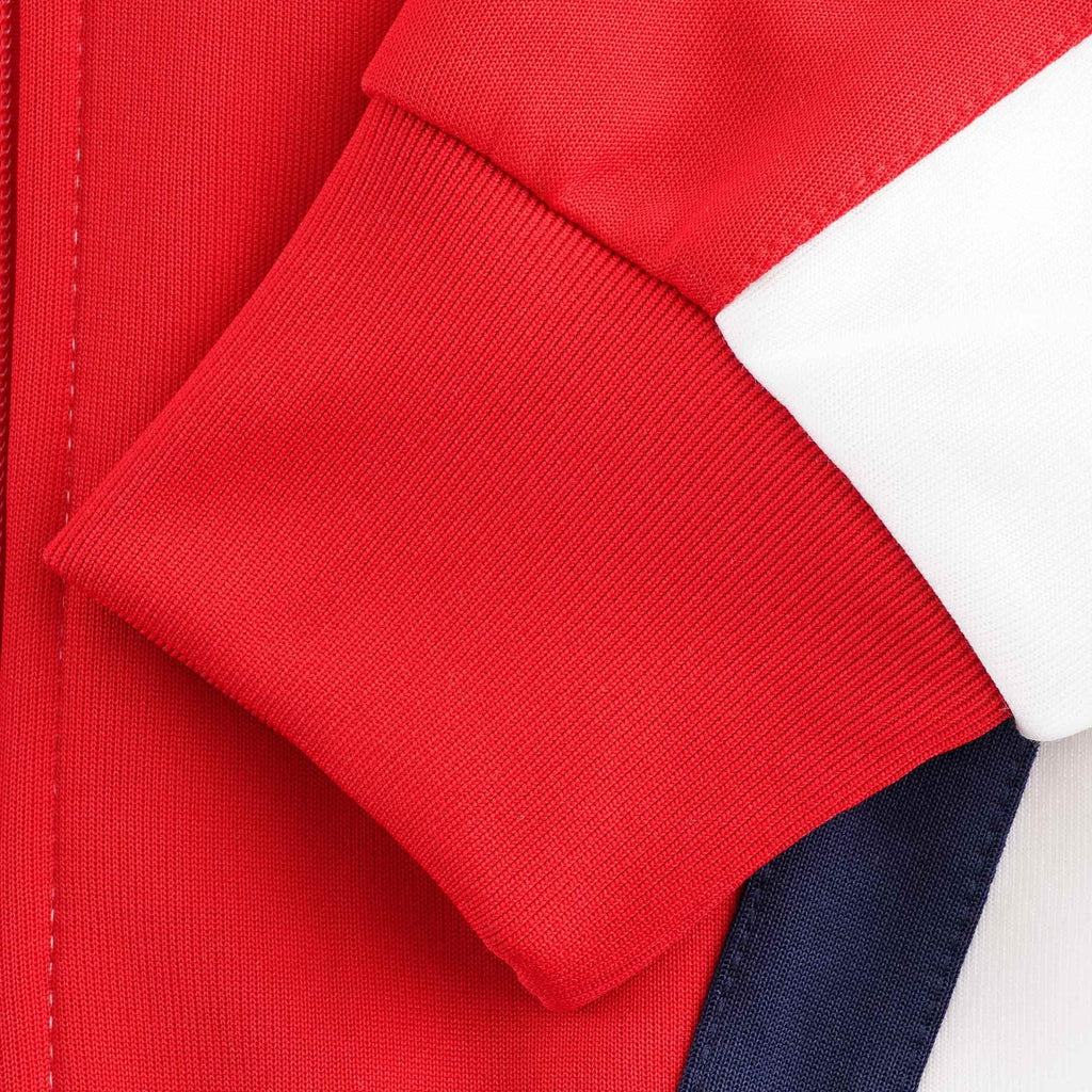 A close-up of the red ribbed cuff on the sleeve of the Adidas track top.