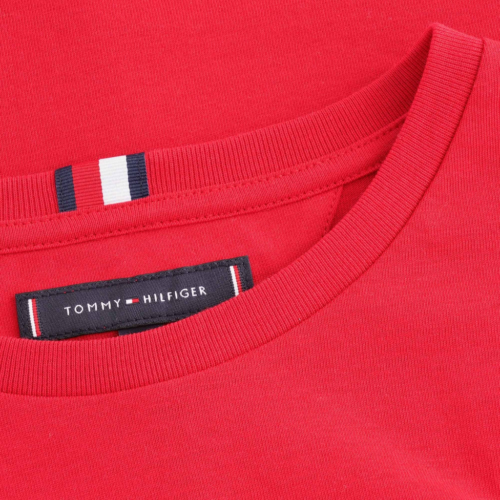 A close-up of the collar and neck tag of the red Tommy Hilfiger T-shirt.