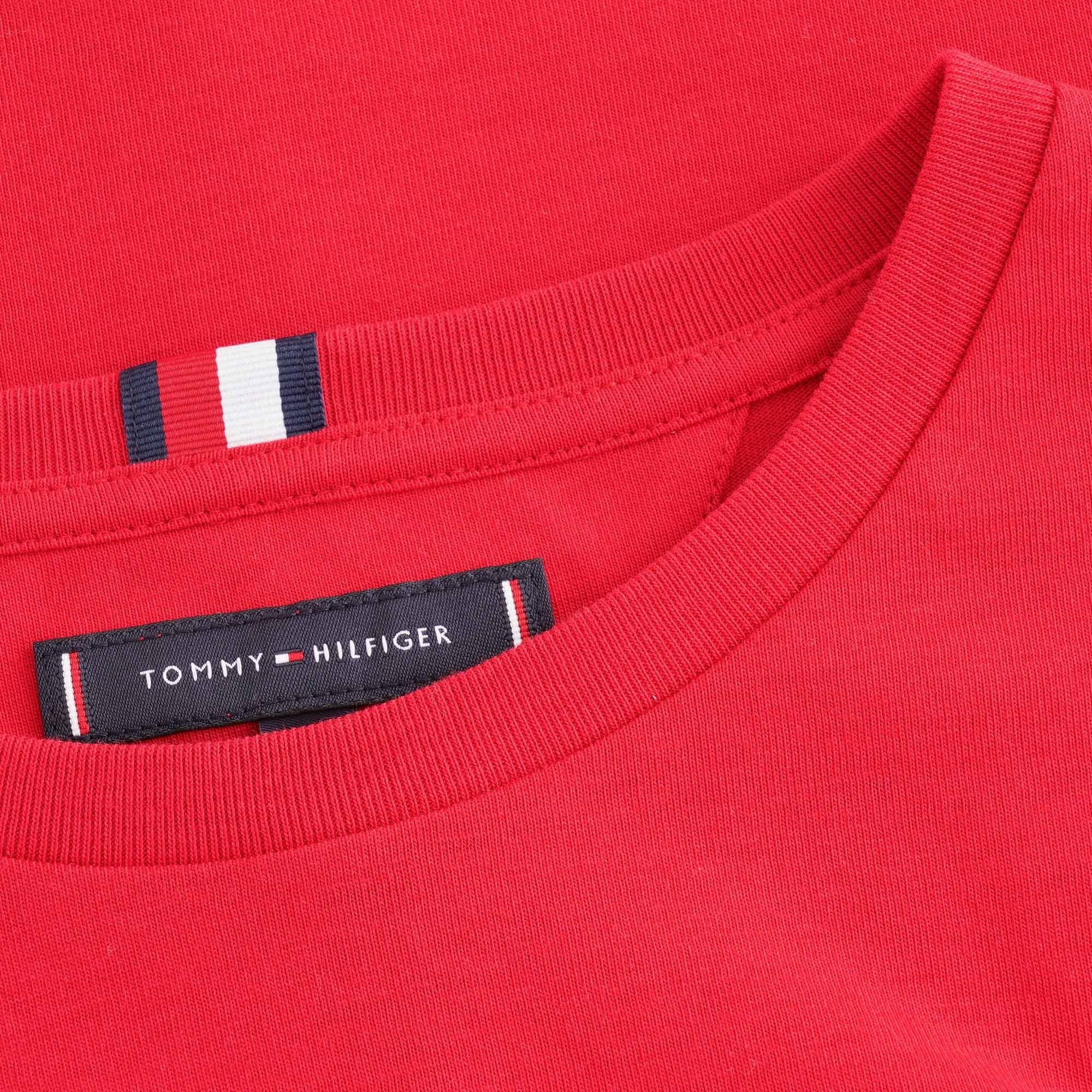 A close-up of the collar and neck tag of the red Tommy Hilfiger T-shirt.