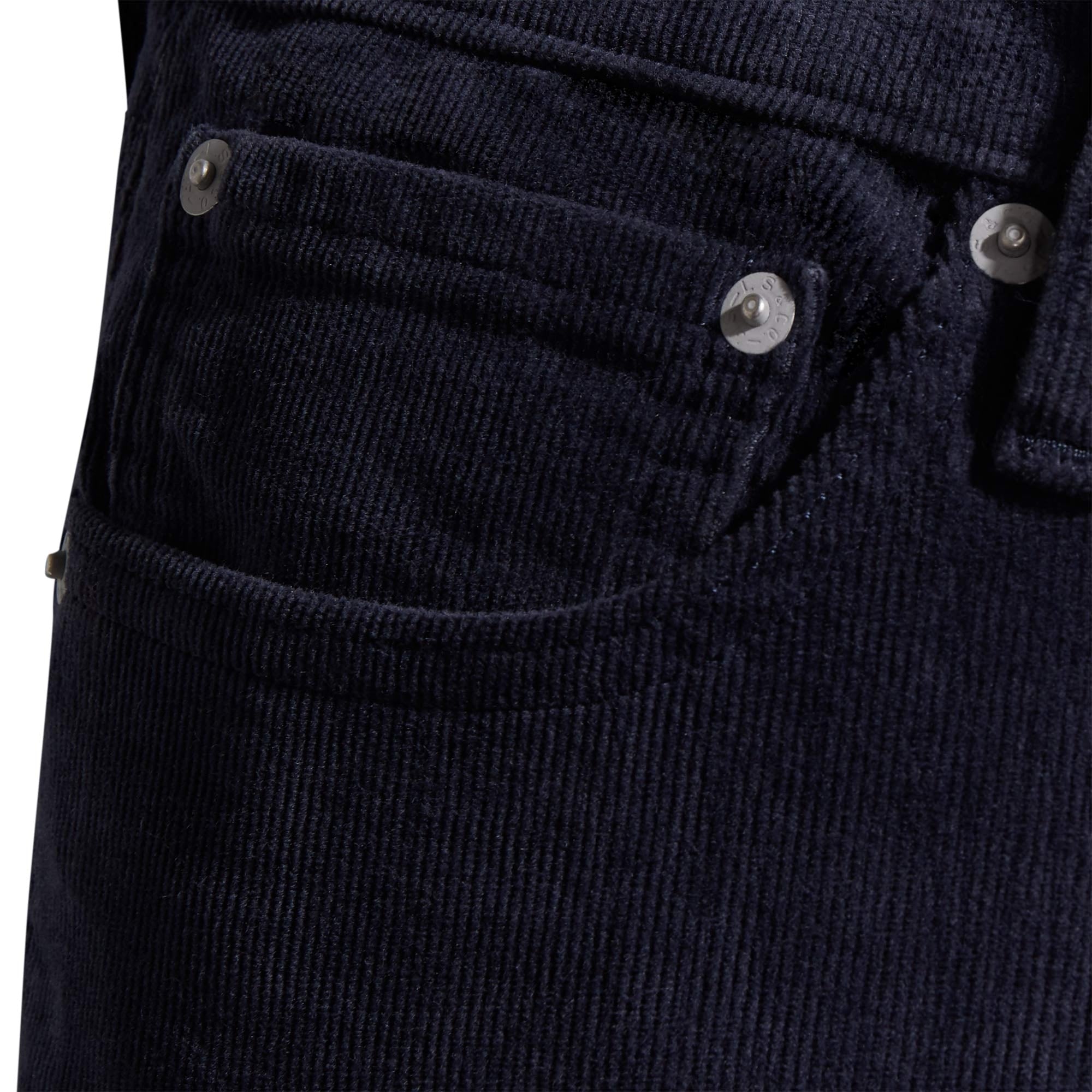 A detailed shot of the front pocket with silver rivets on navy corduroy trousers.