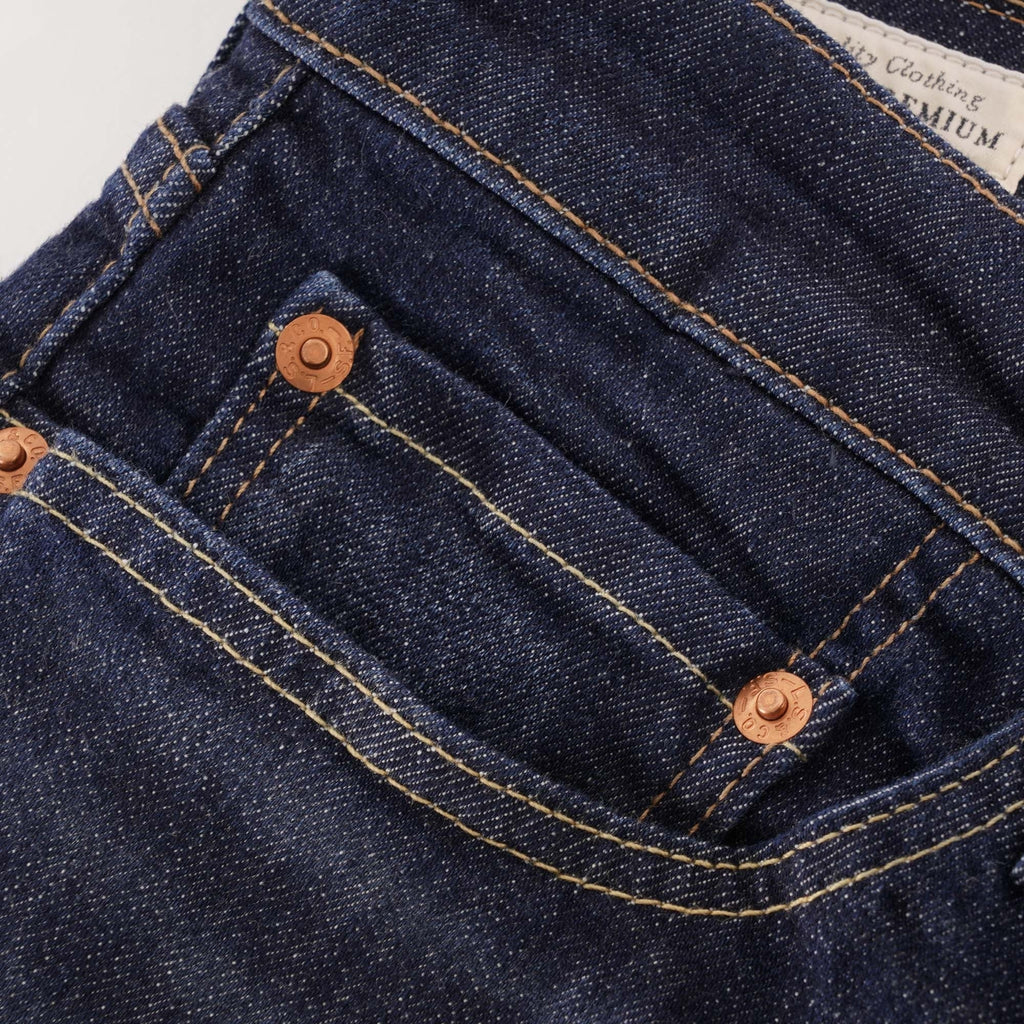 A close-up of the front pocket and copper rivets on the dark wash Levi's jeans.