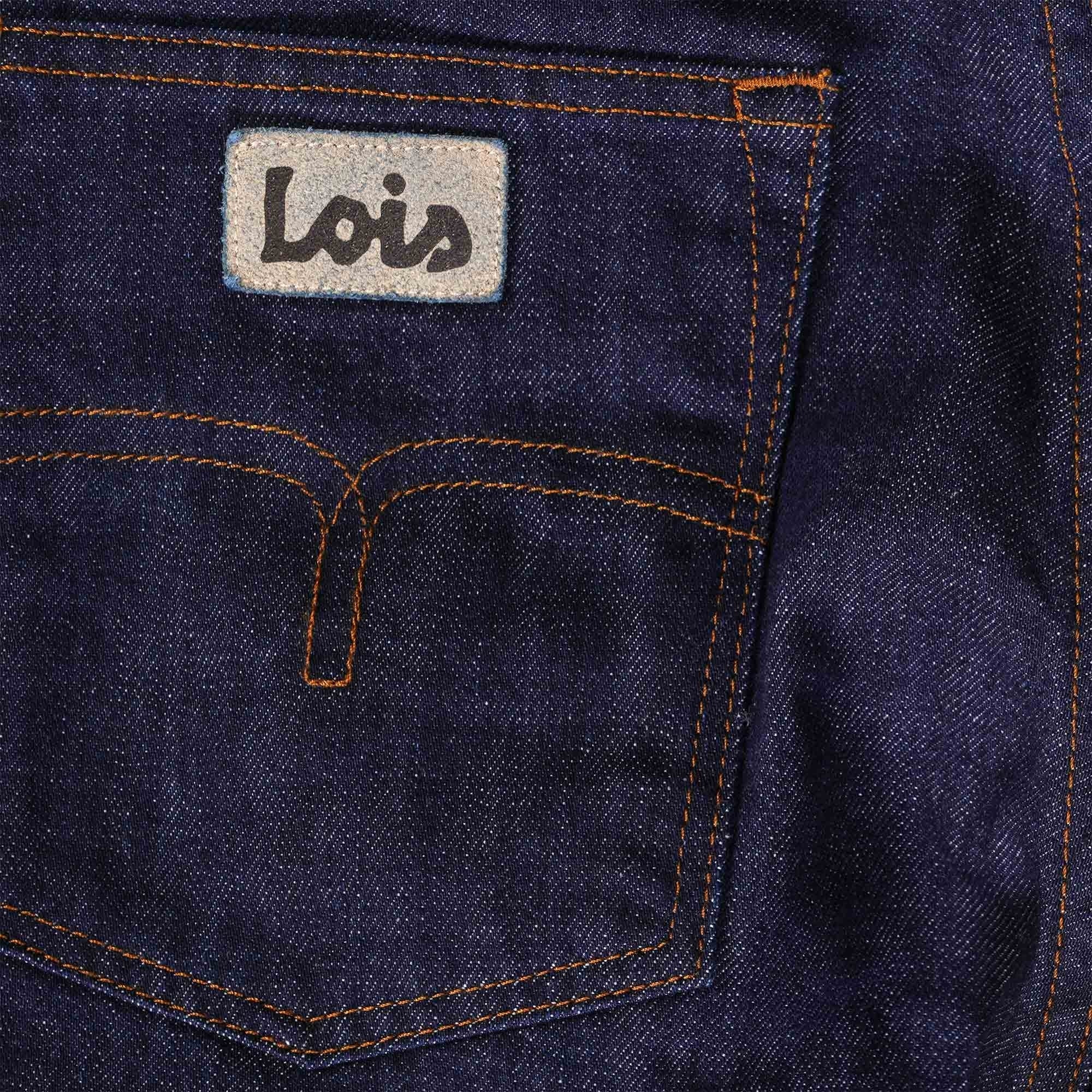 Close-up of the back pocket of men's dark blue jeans with the brand logo and stitching.
