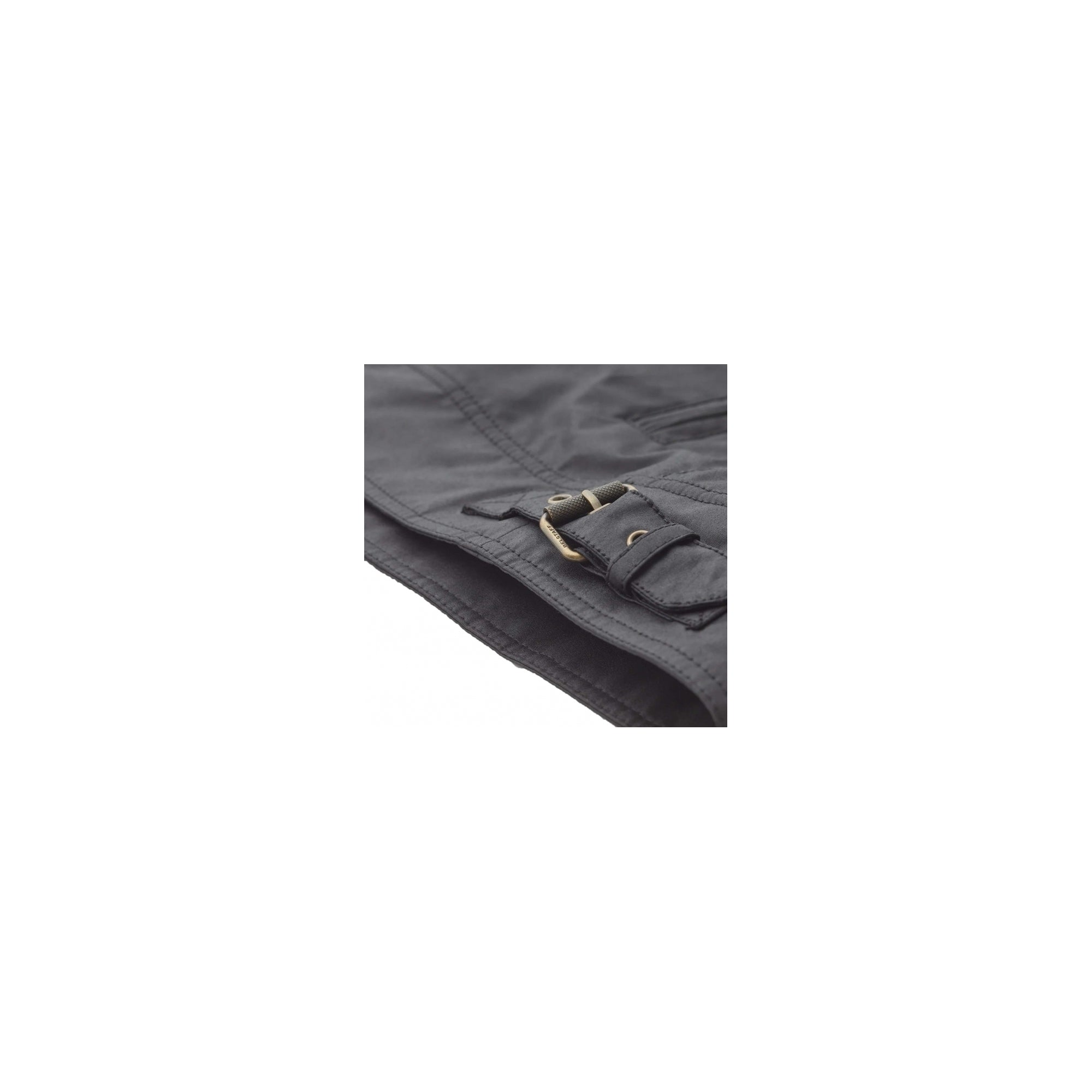 The cuff of a black jacket with a brass buckle for adjustment.